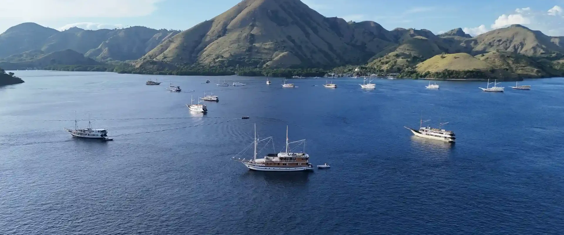 Boats anchored in a calm bay beside a tropical island